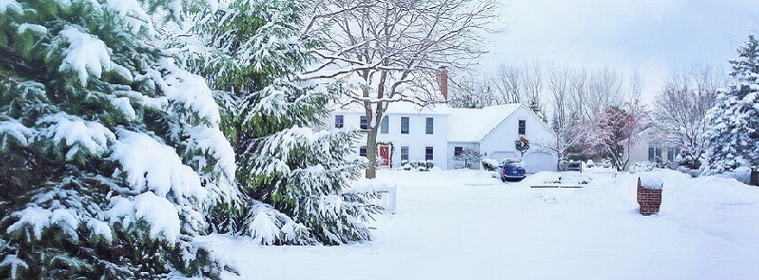 En snötäckt tomt med stort hus